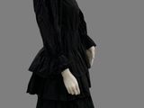 a mannequin wearing a black dress with ruffles on it