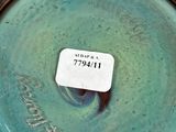 a close up of a blue vase with a tag on it