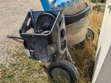 a cement mixer next to a cement wall in a yard