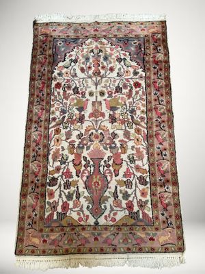 un tapis persan antique avec un motif floral sur fond blanc