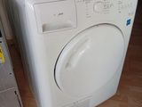 une machine à laver blanche posée par terre à côté d'un ordinateur portable