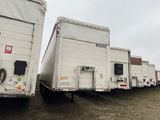 de nombreux semi-remorques blancs garés en rangée sur l'herbe