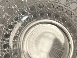 a glass bowl with a wooden handle on a table