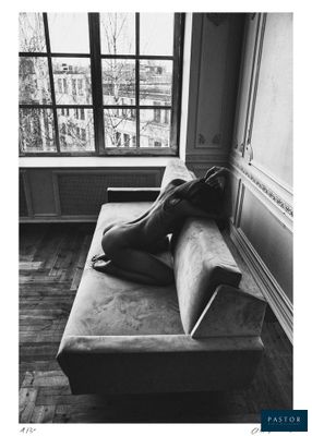 a black and white photo of a woman laying on a couch