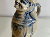 a ceramic figurine of a man wearing a hat and scarf
