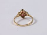 a close up of a gold ring with a red stone