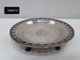 a silver plate on a stand on a white surface