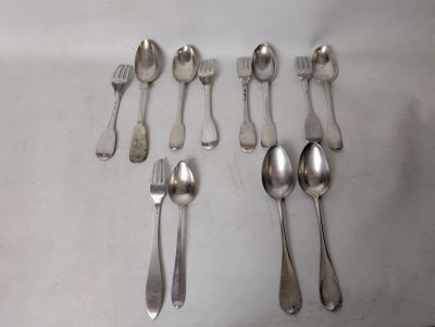 six spoons and six forks laid out on a table