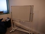 un tableau blanc posé sur un support dans un coin de la pièce
