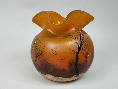 un vase en verre décoré d'une peinture, posé sur une table