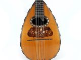 an image of a mandolin that is sitting on a white surface