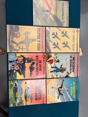 une pile de livres posés sur un réfrigérateur bleu