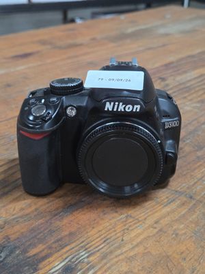a camera sitting on a wooden table with a card attached to it