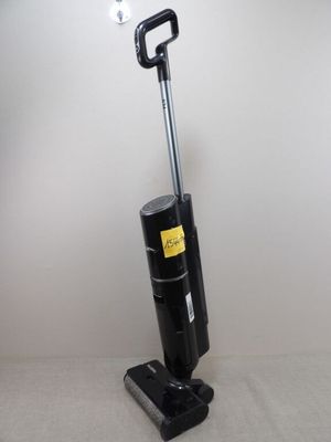 un gros plan d'un aspirateur posé sur un lit dans une chambre