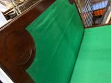 a wooden bench with a green seat in a room