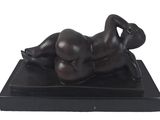 statue of a woman reclining on a black base on a white background
