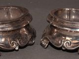 two silver bowls sitting on top of a table
