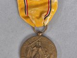 une vieille médaille entourée d'un ruban, posée sur une surface blanche