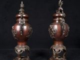 two vases that are sitting on a black surface