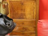 a black bag sitting next to a wooden dresser in a room