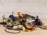 a pile of assorted jewelry on a wooden table