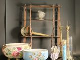a shelf that has a bowl, candle, and other items on it