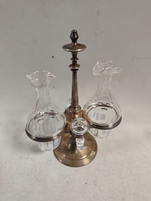 trois vases en verre et un bougeoir en laiton posés sur une table