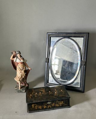 une statue représentant un homme debout à côté d'un miroir et d'une boîte
