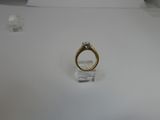 a gold ring with a diamond on it on a white surface
