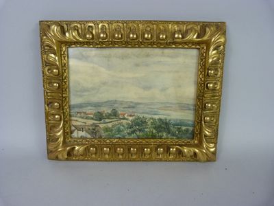 a painting of a landscape in a gold frame on a white wall
