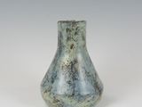 a blue vase that is sitting on a white surface