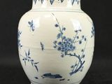 a blue and white vase sitting on a black surface