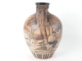 a vase with a painting on it sitting on a table