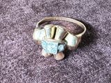 an image of a silver ring with a blue stone in the center