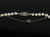 a white pearl and gold bracelet with a silver clasp