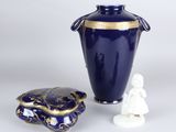 un vase bleu et une petite figurine blanche à côté