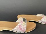pair of women ' s slippers on a black surface with a black background