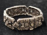 gros plan d'un bracelet en argent sur une surface noire