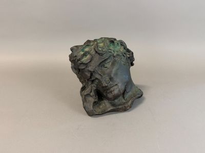 a close up of a statue of a head on a white surface