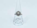 une image représentant une bague en diamant posée au sommet d'un cône transparent
