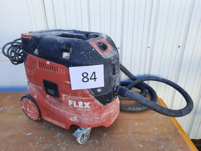 un aspirateur rouge et noir posé sur une table en bois