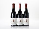 trois bouteilles de vin rouge posées sur une table blanche