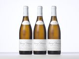 three bottles of white wine sitting on top of a table