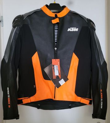 an orange and black jacket hanging on a hanger in a room