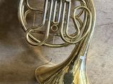 an antique brass french horn sitting on top of a black table