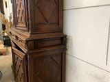 a large wooden cabinet next to a wall with a picture on it