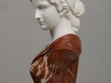 marble bust of a woman with braided hair on a table