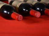 several bottles of wine are lined up on a red table