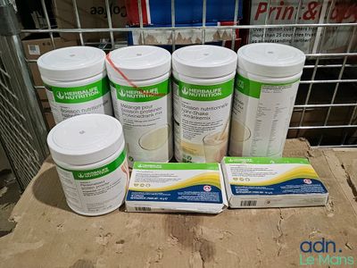 six bouteilles de protéines posées sur une table à côté d'un carton de lait