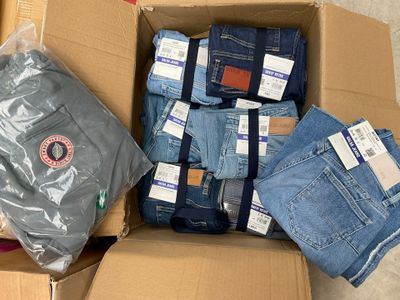 de nombreux jeans dans une boîte posée par terre